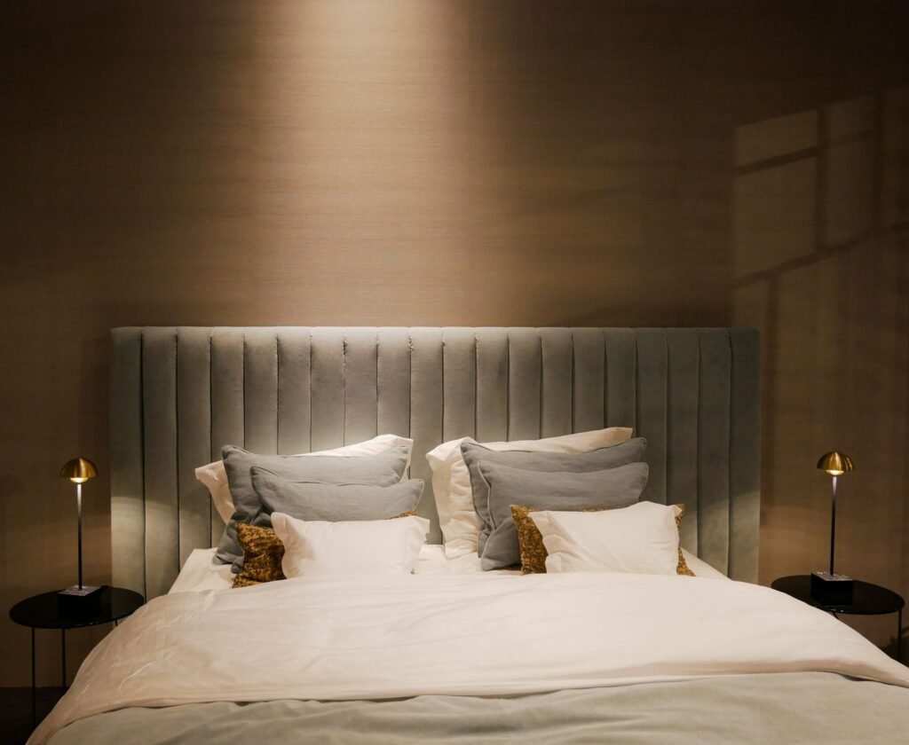 Bed with a ribbed upholstered headboard and small bedside lamps (illustrative stock image)