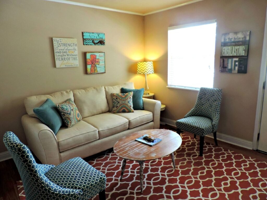 Living room with beige sofa and patterned chairs (illustrative stock image)