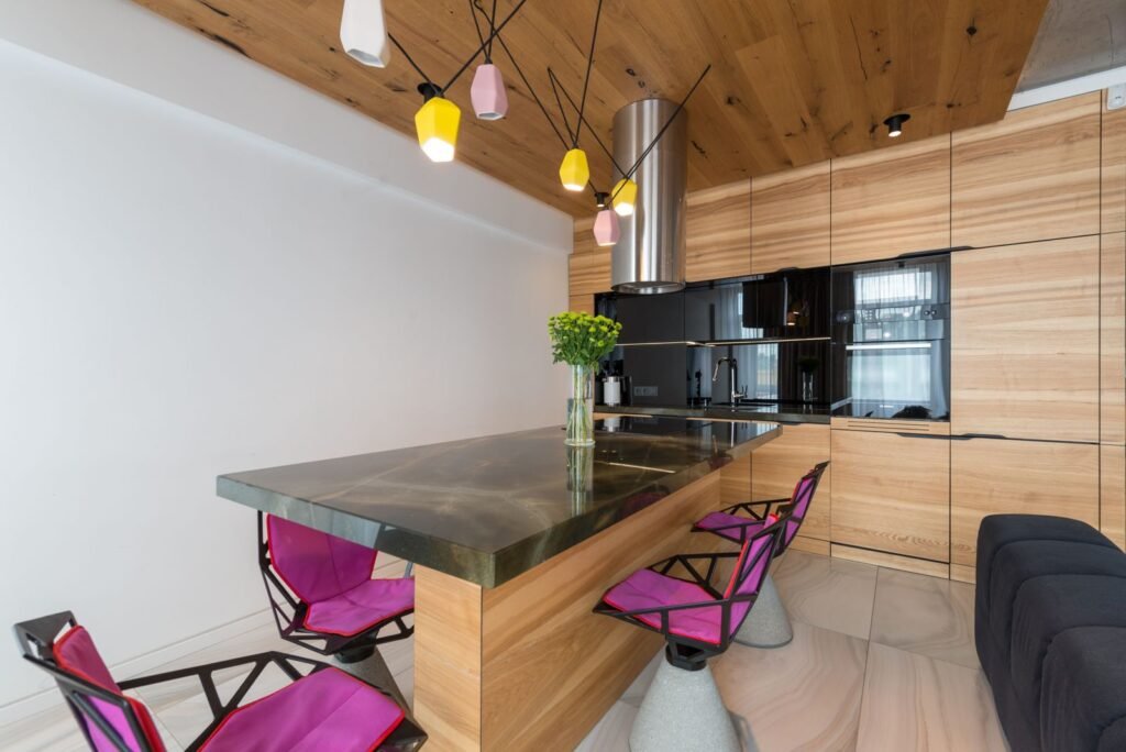 Kitchen island with wood panelling, pendant lights and chairs (illustrative stock image)