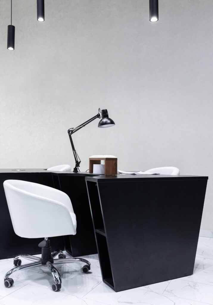 Black office desk with a white chair and adjustable lamp (illustrative stock image)
