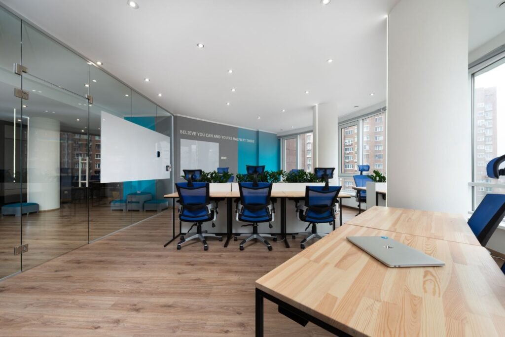Meeting room with a long wooden table and glass partition walls (illustrative stock image)