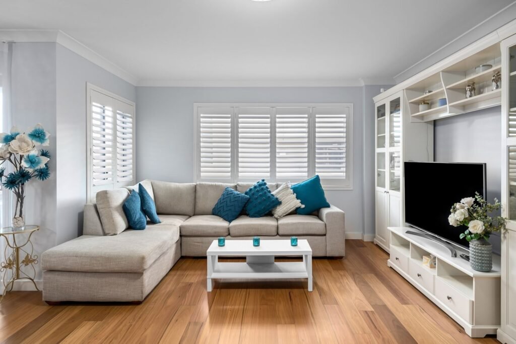 Living room with a TV unit beside white display shelving (illustrative stock image)